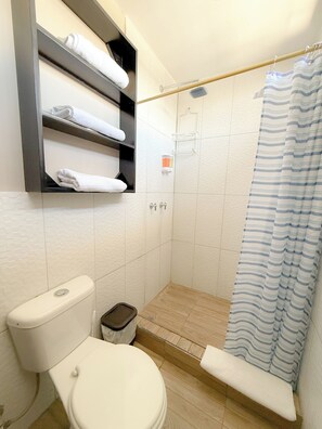 Chuveiro, toalhas de banho, sabonete, papel higiênico