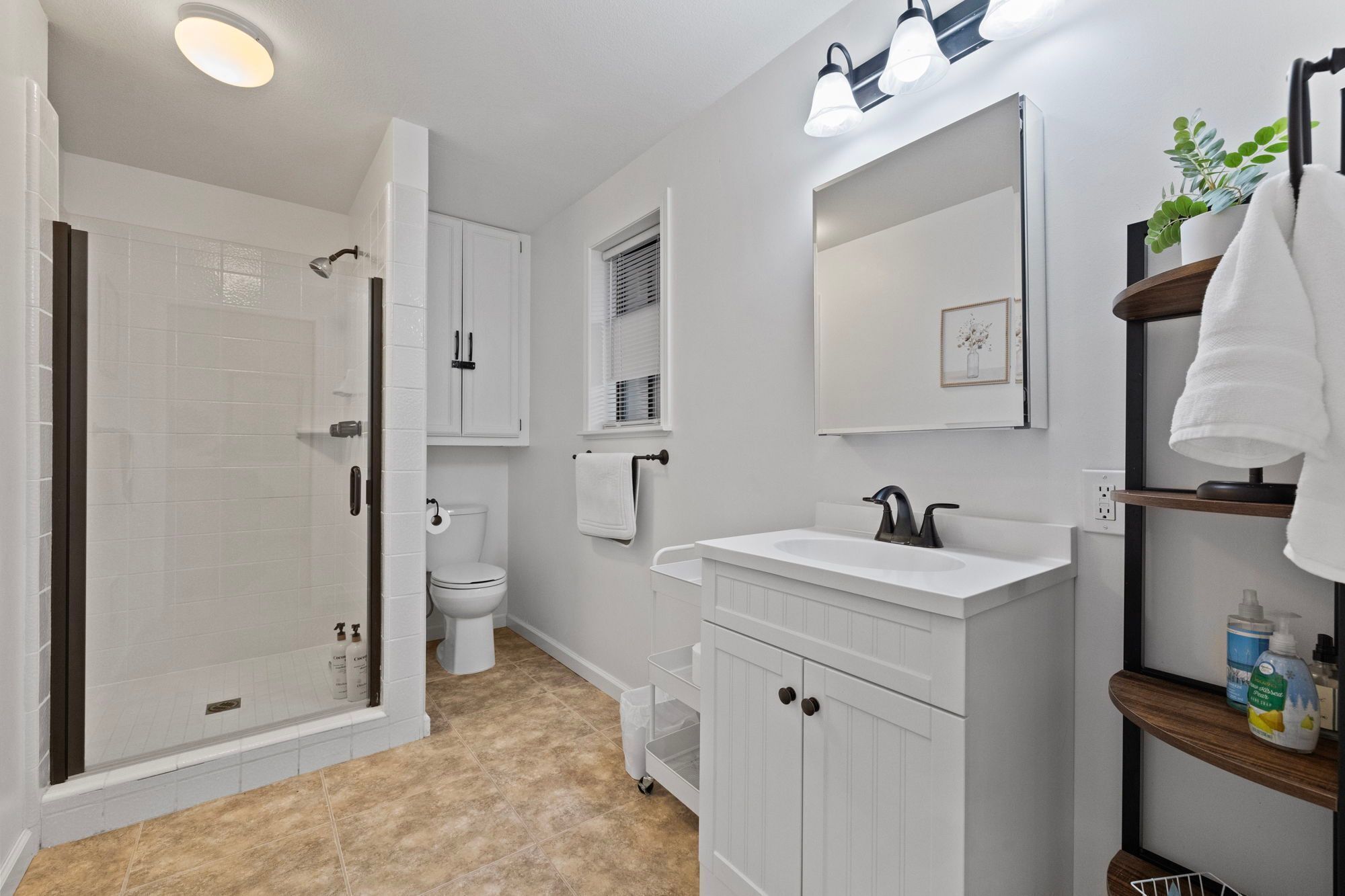 Een moderne badkamer met een inloopdouche, toilet en wastafel.