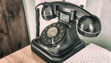 Un telefono nero d'epoca su un tavolo di legno.