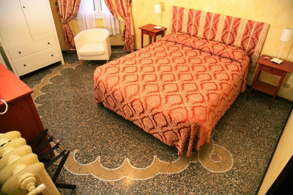 Ein Hotelzimmer mit Bett, Stuhl, Kleiderschrank und einem kleinen Tisch.