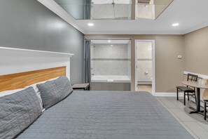 Une chambre moderne avec un grand lit, une douche et un coin repas.