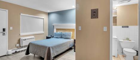 Une chambre à coucher avec un lit, une table de chevet et une fenêtre.