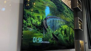 Una sala de estar moderna con un televisor de pantalla plana grande montado en una pared con detalles de mármol.