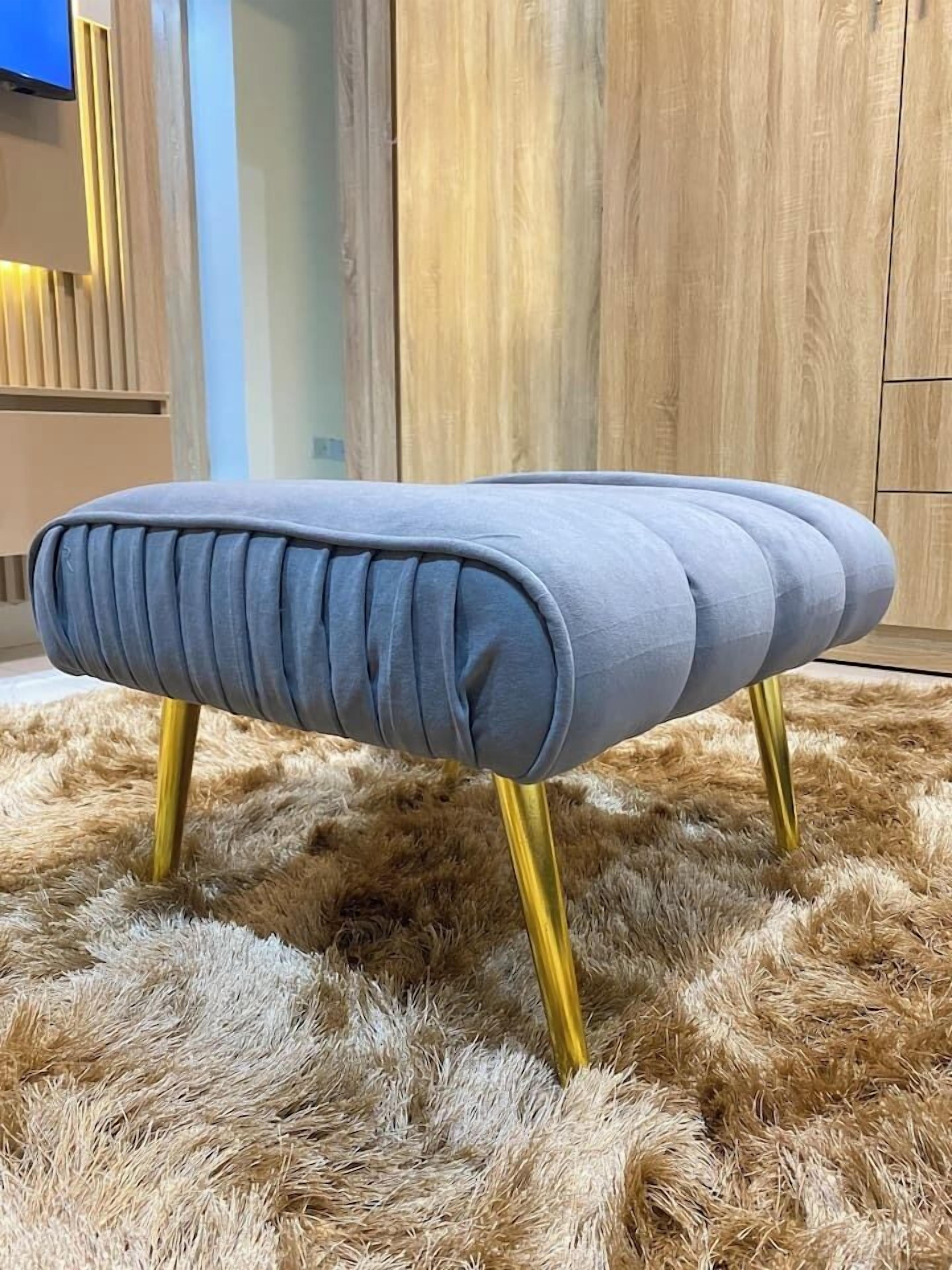 En stoppad bänk med ett metallunderrede, placerad på en lurvig matta.