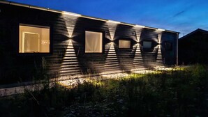 Una casa moderna con fachada oscura y amplias ventanas.