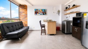 Een moderne keuken met een zwarte koelkast, magnetron en een houten aanrecht.