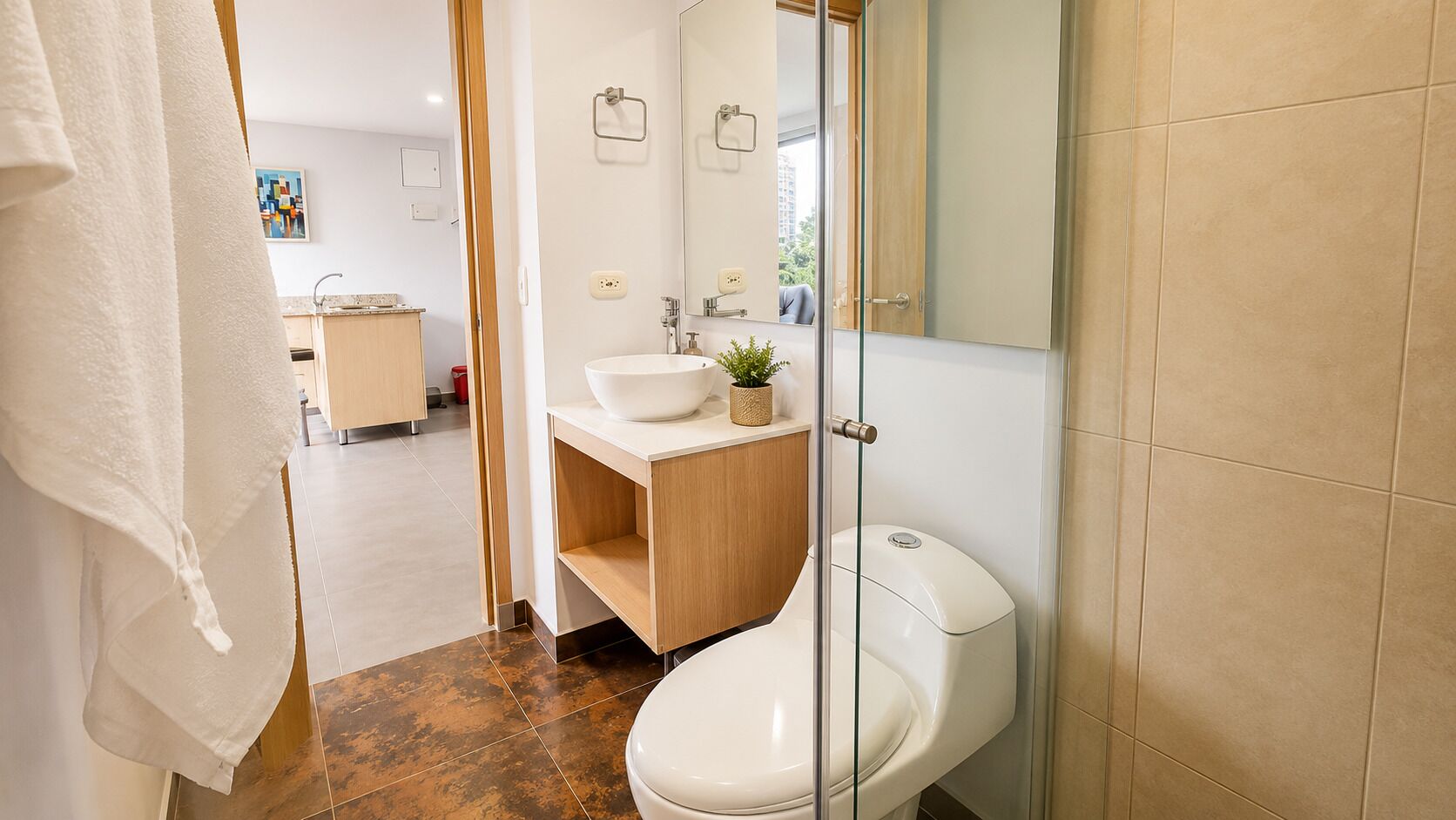 A modern bathroom with a toilet, sink, and mirror.