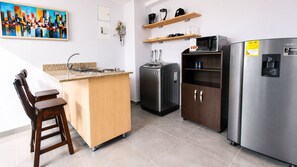 Een moderne keuken met een houten kookeiland, roestvrijstalen apparatuur en een koffieapparaat.