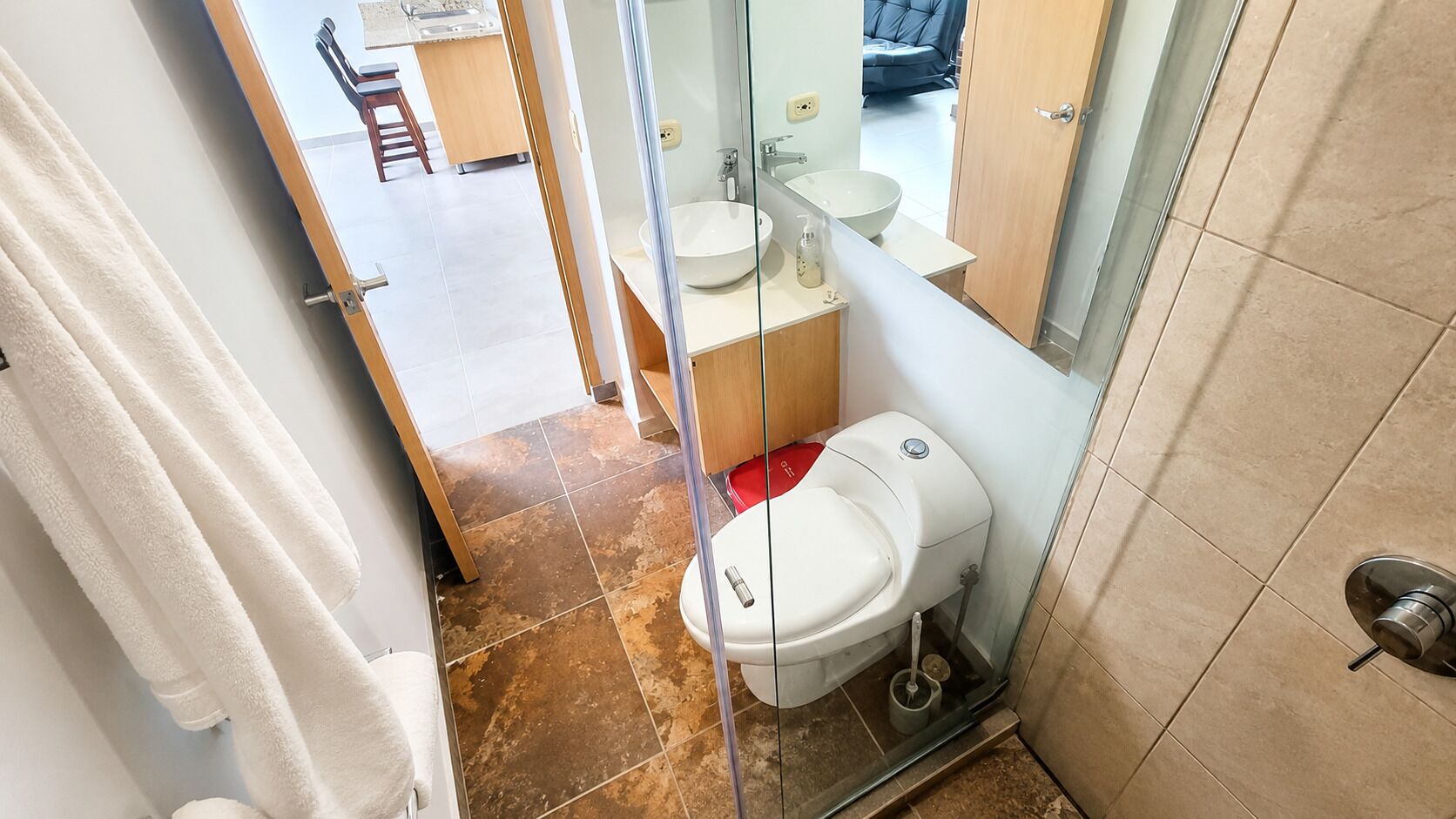 A bathroom with a toilet, sink, and shower area.
