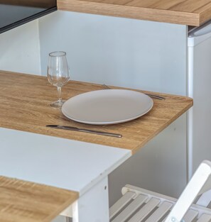 A dining table with a plate, a fork, and a glass.