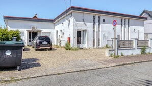 Un edificio con techo rojo, un cartel de no estacionamiento y un coche negro estacionado adelante.