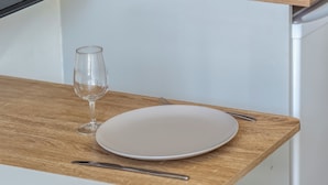 Una mesa con un plato, un tenedor y una copa.