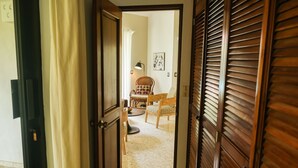 A hallway with a wooden door, a wicker chair, and a table with a lamp. - Charming oceanfront 3 BR villa in Cabarete Center (Cabarete)