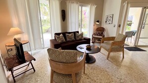 A living room with a sofa, two patterned chairs, a small table, and a lamp. - Charming oceanfront 3 BR villa in Cabarete Center (Cabarete)
