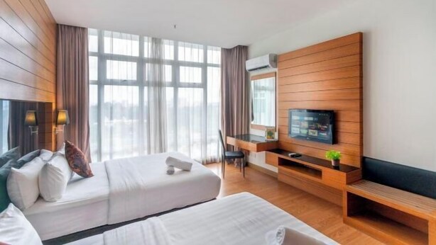 Une chambre d’hôtel avec un lit, un bureau, une télévision et une grande fenêtre.