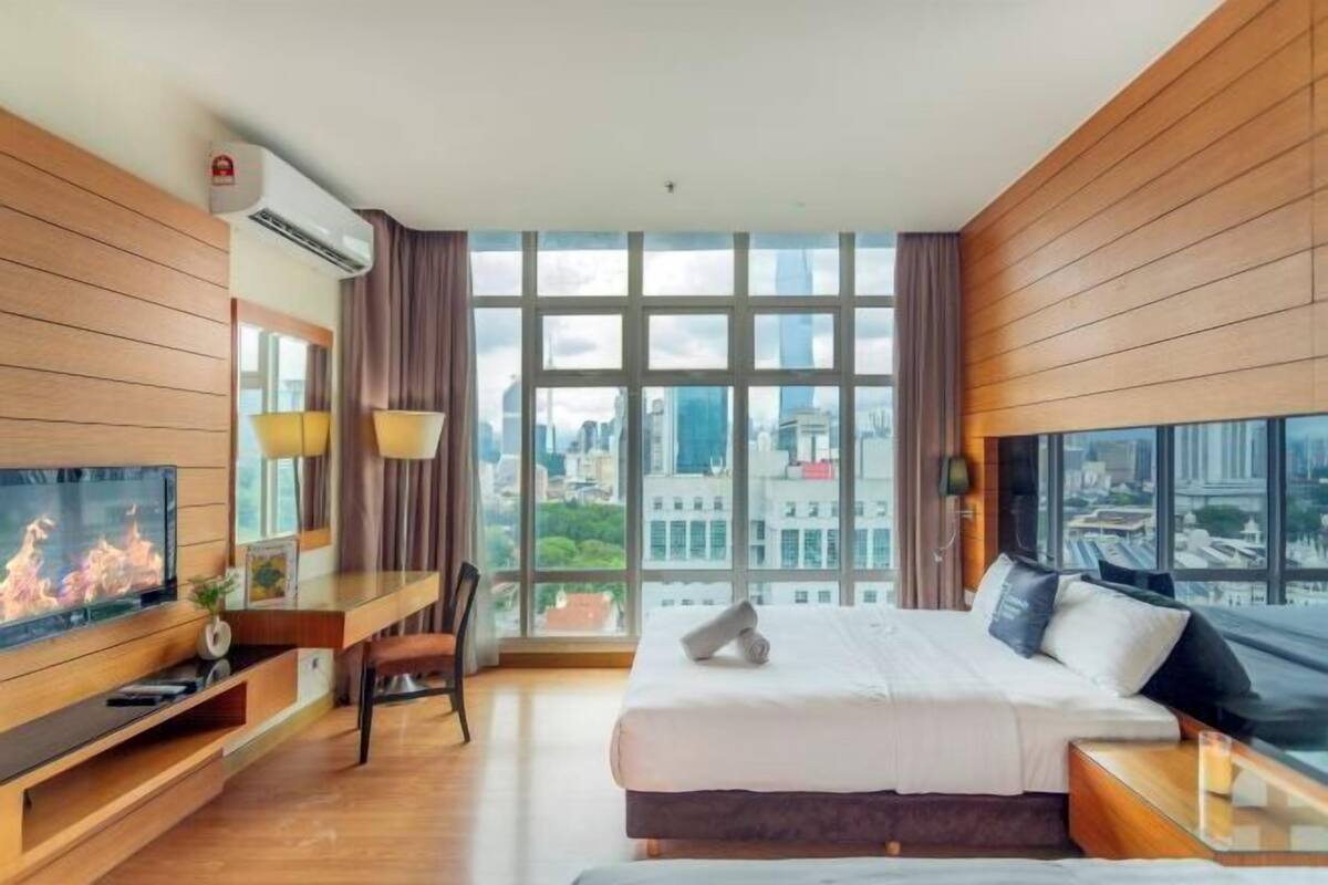 Een moderne hotelkamer met een groot raam, een bed, een bureau en een televisie.