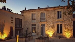 Un edificio de piedra de dos pisos con un patio central, destacando una puerta principal y ventanas en el nivel superior.