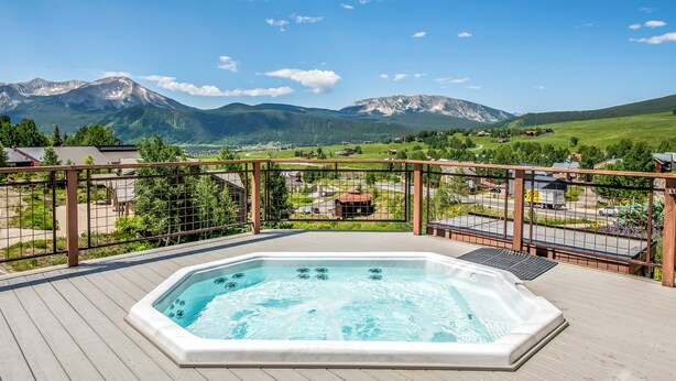 A hot tub on a wooden deck with a mountain view. - Mountain Edge Condo Mt Crested Butte (Crested Butte)