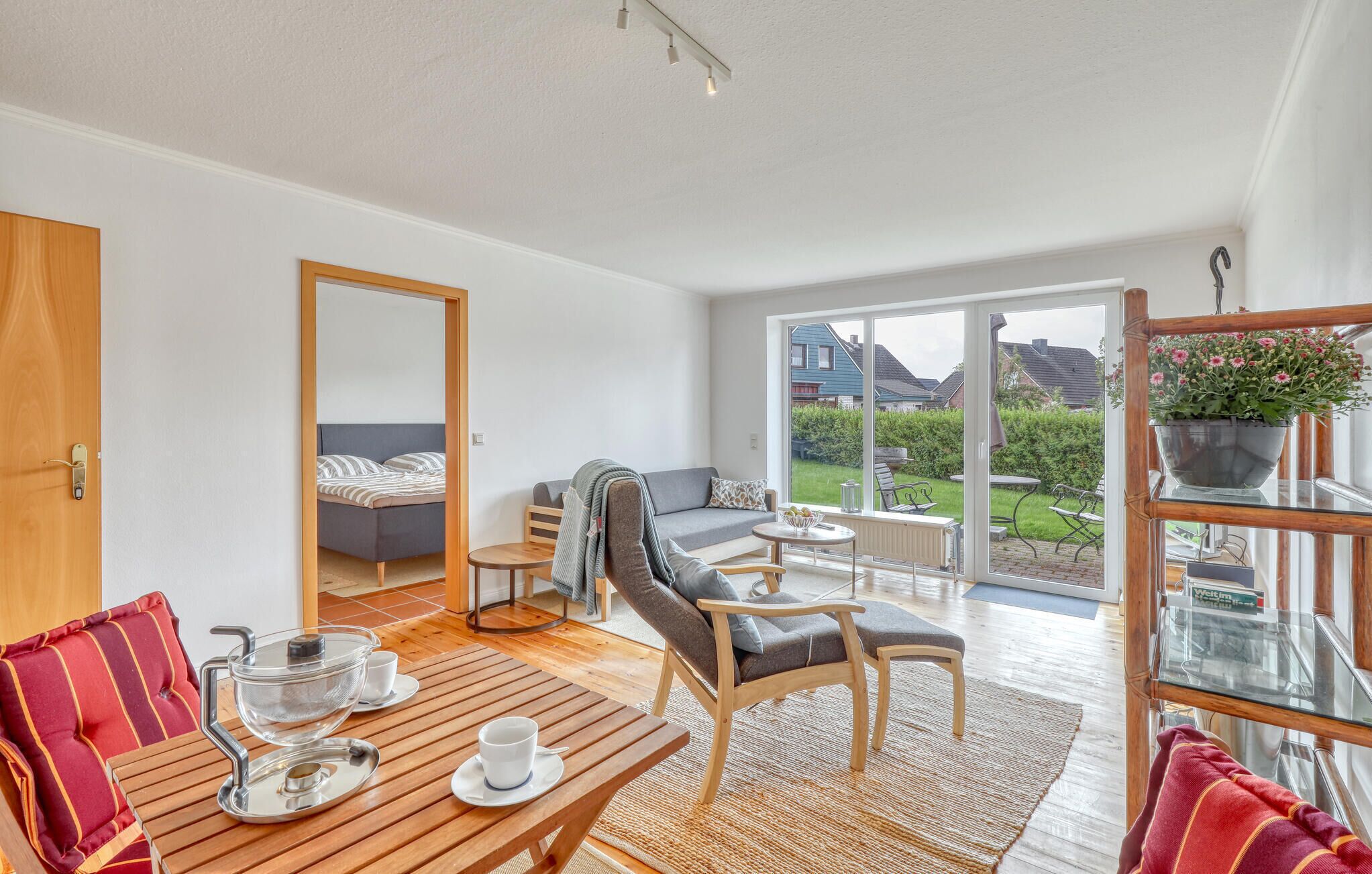 A modern living room with a sofa, chairs, a dining table, and a view of the outside.