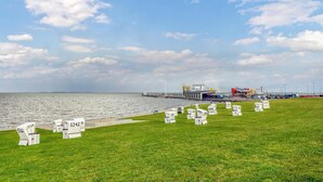 A grassy area with numbered markers, a body of water, and industrial structures in the background. - Awesome apartment in Klanxbüll with WiFi (Klanxbüll)