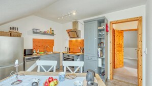A compact kitchen with a wooden countertop, a built-in oven, and a dining area with a table set for two. - Awesome apartment in Klanxbüll with WiFi (Klanxbüll)