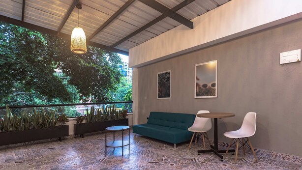 A modern lounge area with patterned flooring, a teal sofa, white chairs, and hanging lights. - NOK Charming Loft in Laureles (Medellín)