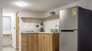 A modern kitchen with wooden cabinets, a stainless steel refrigerator, and a built-in coffee maker. - NOK Charming Loft in Laureles (Medellín)