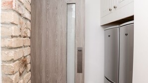 Une cuisine avec une porte en bois, un bouton-poussoir et des appareils électroménagers en acier inoxydable.