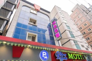 A building with a neon sign for a motel, a parking sign, and a visible entrance. - Ritz Sillim (Seoul)