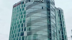 A tall, modern building with a curved glass facade and the 'poco' logo at the top. - Ritz Sillim (Seoul)