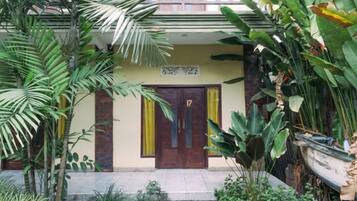 A building with a front door, a balcony, and a sign above the door.