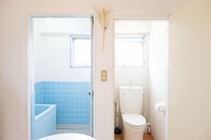 Une salle de bain avec des toilettes, un lavabo et une baignoire.