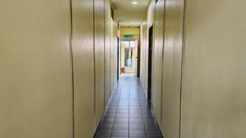 A long, narrow hallway with a tiled floor and walls painted in a light color.