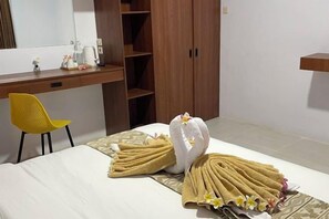 Una habitación de hotel con cama, escritorio, silla y armario.