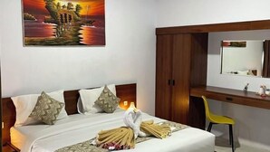 Una habitación de hotel con una cama, un escritorio, una silla, un espejo y un cuadro en la pared.