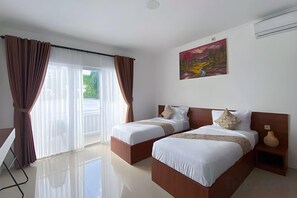 Habitación de hotel con dos camas, un ventanal con cortinas, un cuadro en la pared y un florero en la mesita de noche.