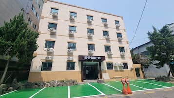 A multi-story hotel with a sign reading 'Hotel Motel' on the front.