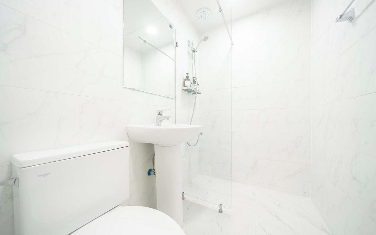 Une salle de bain avec des toilettes, un lavabo et une douche.