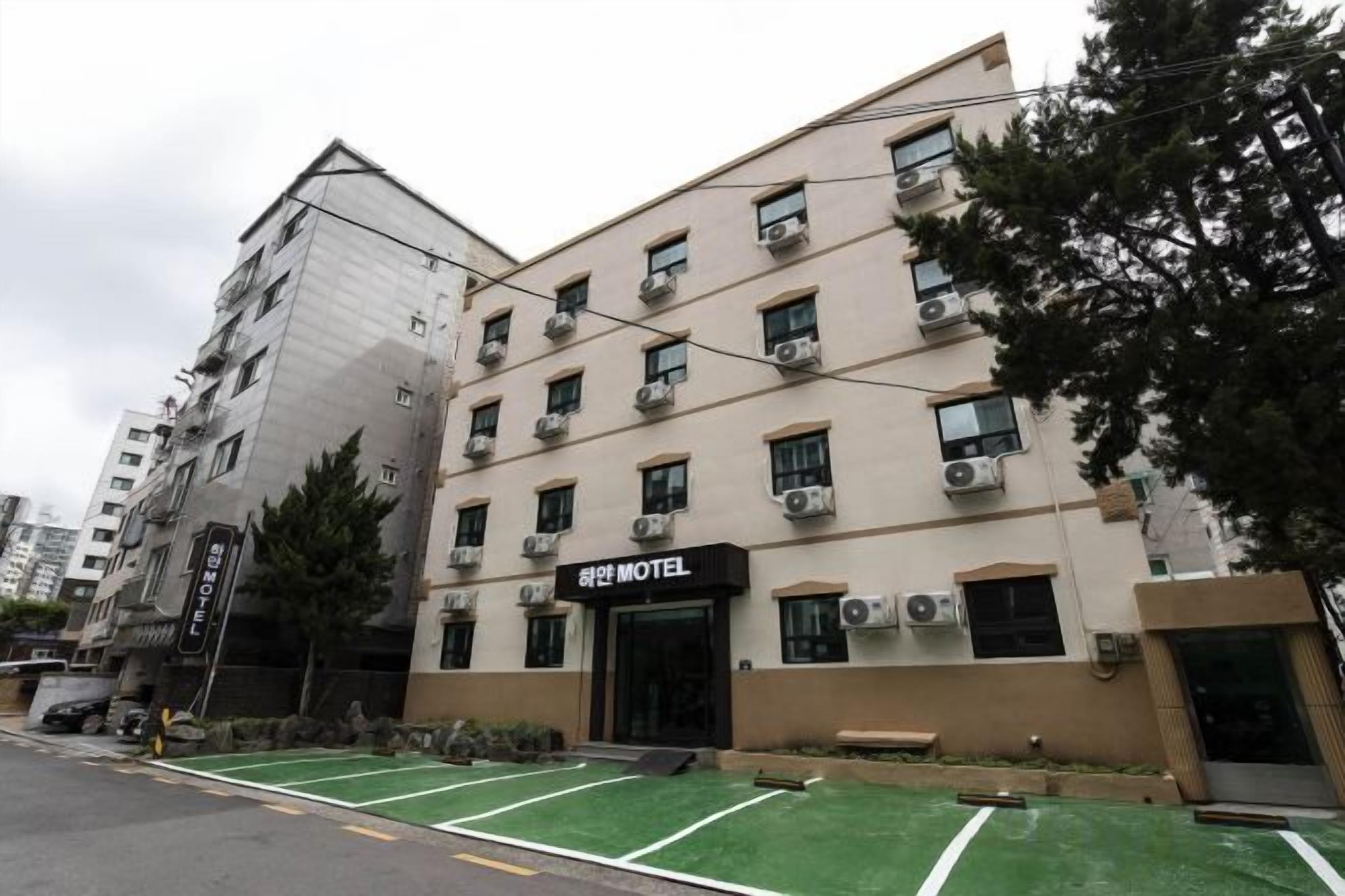 Een meerlaags gebouw met een bord waarop 'Motel' staat, wat een hotel aangeeft. De gevel heeft meerdere ramen en het gebouw heeft een moderne architectuur.