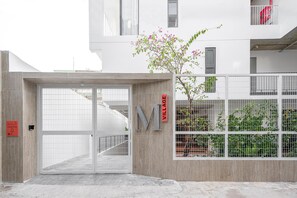 A gated entrance to a building with a sign reading 'M VILLAGE'. - Express by M Village Ky Dong, a brand of Modern Village Lifestyle (Ho Chi Minh City)