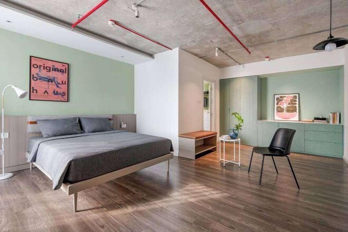 Un dormitorio moderno con una cama, un escritorio y una silla.