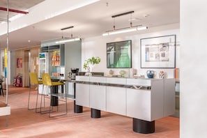 A modern kitchen with a central island, pendant lighting, and a large mirror. - Express by M Village Ky Dong, a brand of Modern Village Lifestyle (Ho Chi Minh City)