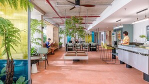 An indoor space with seating areas, a kitchen, and a ceiling fan. - Express by M Village Ky Dong, a brand of Modern Village Lifestyle (Ho Chi Minh City)