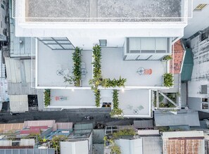 A rooftop terrace with seating and greenery, surrounded by buildings. - Express by M Village Ky Dong, a brand of Modern Village Lifestyle (Ho Chi Minh City)