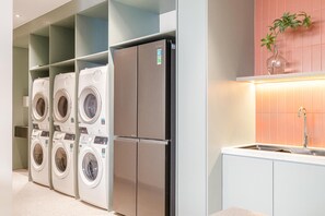 A laundry room with multiple washing machines and a refrigerator. - Express by M Village Ky Dong, a brand of Modern Village Lifestyle (Ho Chi Minh City)
