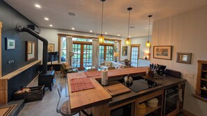 A modern kitchen with a central island, bar stools, and pendant lighting.
