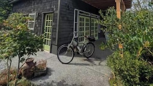 A two-story house with a covered porch and a bicycle parked in front.