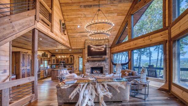 A spacious living area with a large wooden ceiling, a fireplace, and a view of the outdoors. - New! Mtn Views, pool table, fire pit (Blue Ridge)