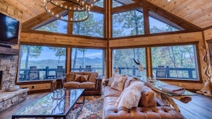 A spacious living room with a large wooden ceiling, a fireplace, and a sofa with a fur throw. - New! Mtn Views, pool table, fire pit (Blue Ridge)