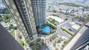 A high-rise building with a pool and surrounding greenery. - Thao Dien Masteri Riverside - Saigon Home (Ho Chi Minh City)